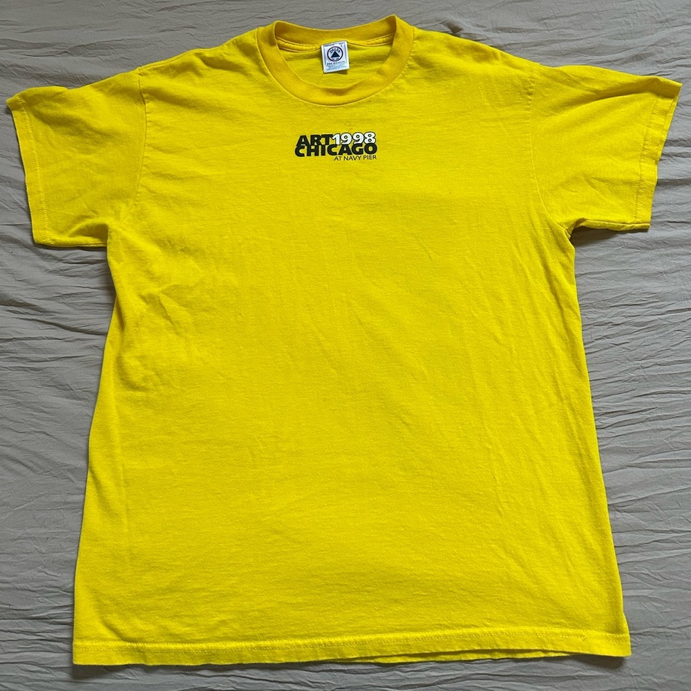 Vintage yellow graphic tee with male figure on the back